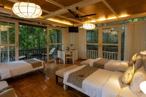 a bedroom with four beds and a balcony at Jungle Village Unawatuna in Unawatuna