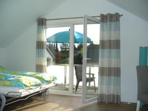 ein Schlafzimmer mit einem Bett und einem Sonnenschirm auf dem Balkon in der Unterkunft Ferienwohnung Rheinaue in Köln