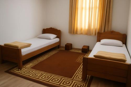 a small room with two beds and a rug at فندق السعادة in Al Qarn