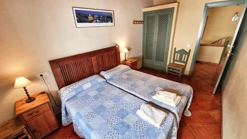 ein Schlafzimmer mit einem Bett mit blauer Bettdecke in der Unterkunft Casa Tinoco Casa Rural Categoria Superior in Fuenteheridos