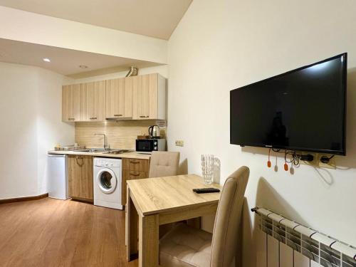 a kitchen with a table and a television on the wall at Pinko apartments in Yerevan