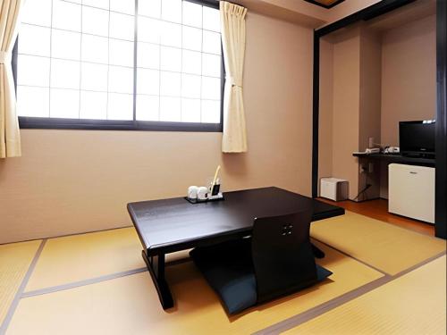 a room with a black table and a window at Hotel The Grand Court Matsusaka in Tsu