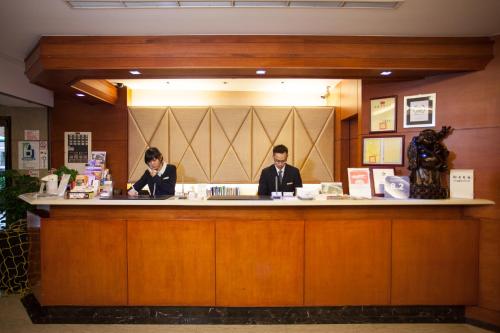 two people sitting at a bar in a restaurant at Rich Garden Hotel in Taipei
