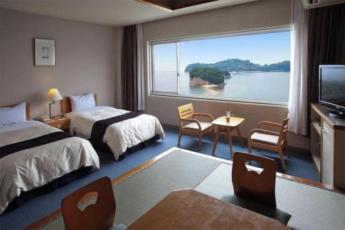 a hotel room with two beds and a large window at Shodoshima International Hotel in Tonosho