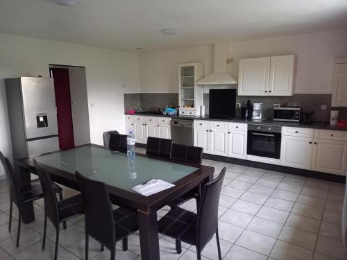 a kitchen with a table and chairs in a room at Le calme a proximité de la ville in Erbray