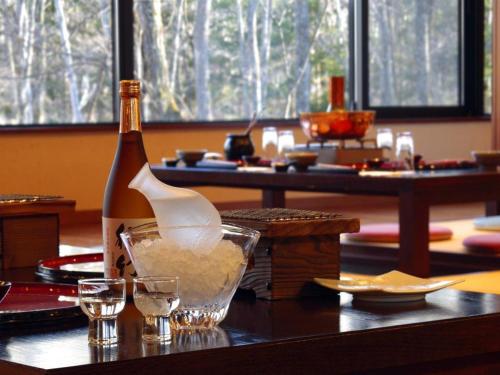 a bottle of wine sitting on a table with glasses at Villa Kitakaruizawa L-Wing in Tsumagoi