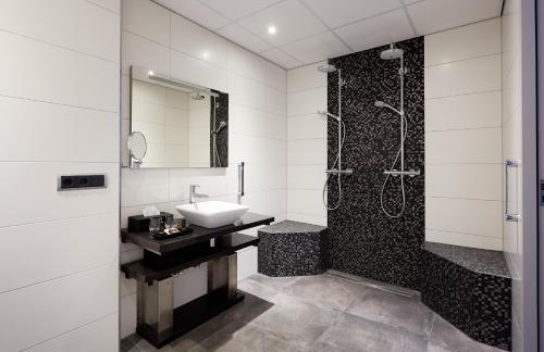 a bathroom with a sink and a shower at Hotel De Lindeboom in Den Burg
