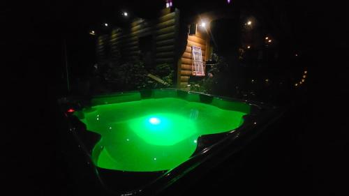 una luce verde in un cortile di notte di Leśna Rezydencja z plażą nad Zalewem Chańcza, sauna, bania SPA a Pągowiec
