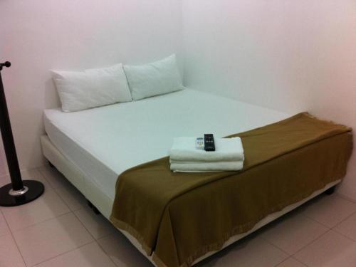 a bedroom with a bed with a remote control on it at Chin Yee Hotel in Teluk Intan