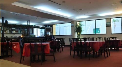 a dining room with tables and chairs and a bar at Klang Histana Hotel in Klang