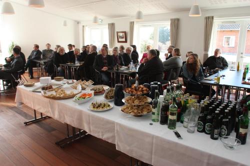 a group of people sitting around a table with food at Hotel Højbysø in Højby