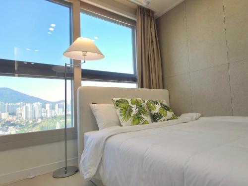 une chambre avec un lit et une grande fenêtre dans l'établissement 부산 서면 레지던스 신축 힐링 하우스, à Busan