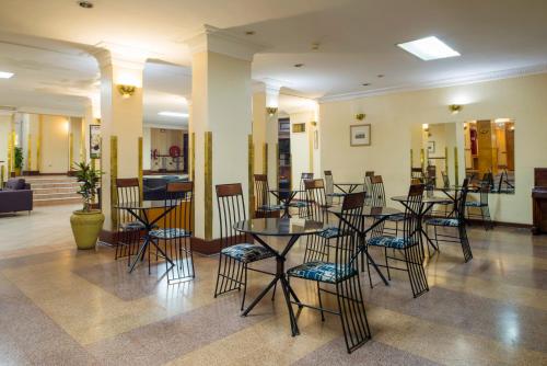 a restaurant with tables and chairs in a lobby at Rainbow Towers Hotel & Conference Centre in Harare