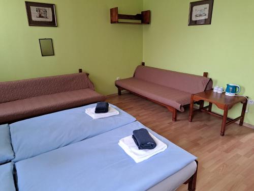a room with two beds and a couch and a table at Hotel Autis in Vysoké Tatry