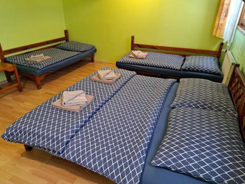 three beds in a room with towels on them at Hotel Autis in Vysoké Tatry