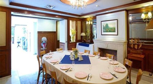 a large dining room with a table and a fireplace at Pearl Hotel Mizonokuchi in Yokohama