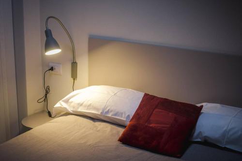 a bedroom with a bed with a lamp next to it at Residenza Cavour - Appartamento D in Tirano