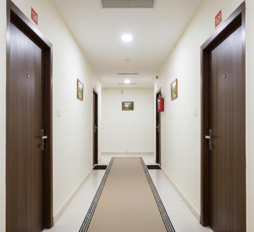 a corridor of a hallway with two doors and a carpet at Premiere Suites - Brookfield in Bengaluru