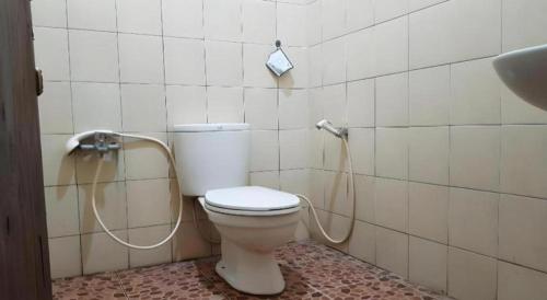 La salle de bains est pourvue de toilettes avec un tuyau connecté. dans l'établissement Hotel O Kopi Klotok Homestay Syariah, à Magelang