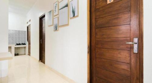 a wooden door in a room with a hallway at OYO 2118 Fh Stay in Yogyakarta