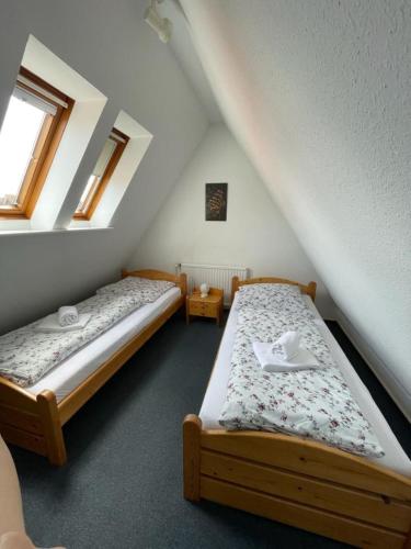 two twin beds in a attic room with windows at Haus Nordseegruß 2 in Cuxhaven