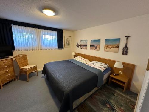 a bedroom with a bed and a desk and a television at Knechtsand 402 in Cuxhaven