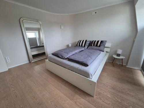 una camera da letto con un letto e un grande specchio di Sunny Flensbo Apartment a Flensburgo