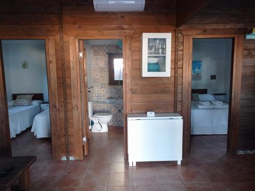 a room with a bathroom with a toilet and a bedroom at El Vivero in Chiclana de la Frontera