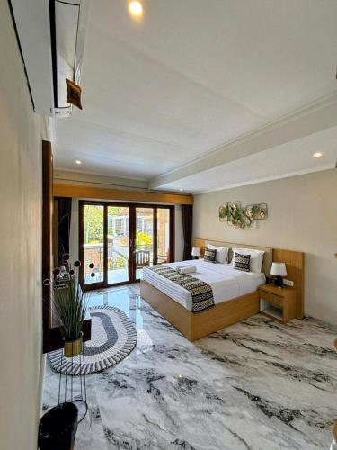 a bedroom with a king sized bed and a marble floor at Mara inn in Nusa Dua