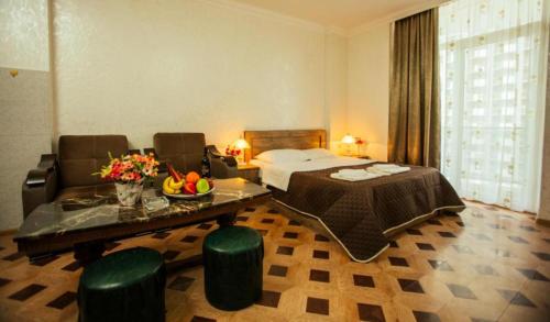 a hotel room with a bed and a table and chairs at Batumi Royal Apartments in Batumi