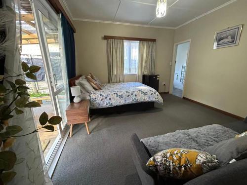a bedroom with a bed and a couch in it at 13 Bedlington in Whangarei