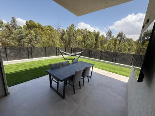 a dining table and chairs on a patio with a garden at וילה יובל in Yuval