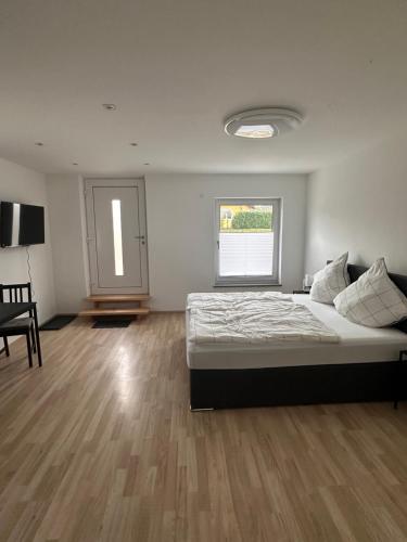 a bedroom with a bed and a table and a window at Ferienwohnung Stefan Frank in Hengersberg