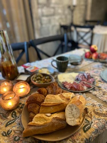 Dreamhome B&B Limoux في ليمو: طاولة عليها أطباق من الخبز وغيرها من المواد الغذائية