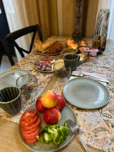 een tafel met borden groenten en fruit erop bij Dreamhome B&B Limoux in Limoux
