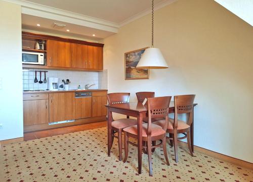 - une cuisine avec une table à manger et des chaises dans l'établissement Balmer See 28 Fereinwohnung für Golfer, à Balm