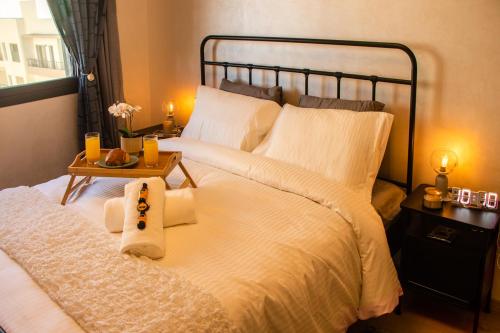 a bedroom with a large white bed with a side table at Ocean Park Sunset Escape beach front with swimming pool in Aïn Harrouda