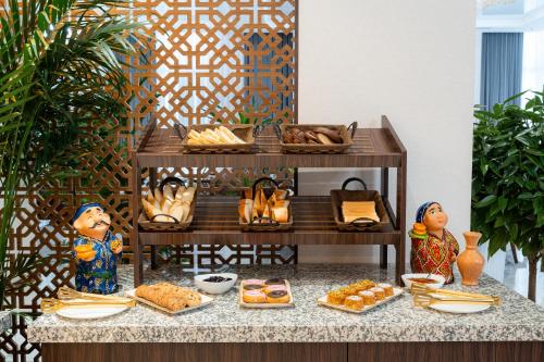 een tafel met daarop een buffet met eten bij Fergana Hotel Tashkent 
