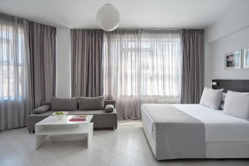 アテネにあるBoss Boutique Athens by Prima Hotelsの大きなベッドとソファのある寝室