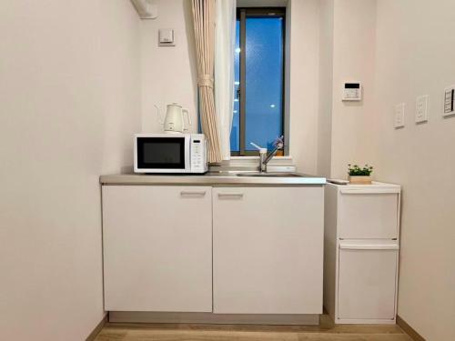 a kitchen with a microwave and a sink at 墨田漢舎3号 in Wada