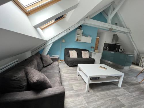 a living room with a couch and a table at Le petit Kichon in Gérardmer