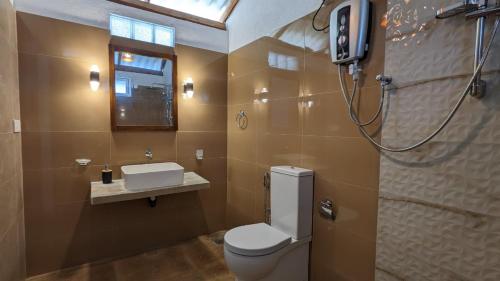 a bathroom with a toilet and a sink at Villa Coleus in Tangalle