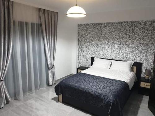 a bedroom with a large bed and a wall with curtains at El Ryo 2 in Călimăneşti
