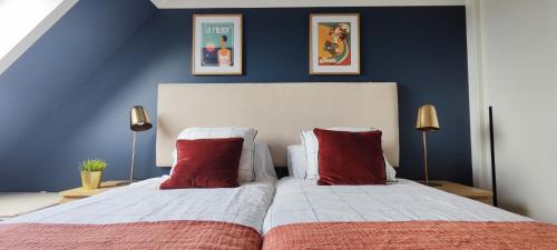 a bedroom with two beds with red pillows at El rincón verde de David y Laura in O Porto de Espasante