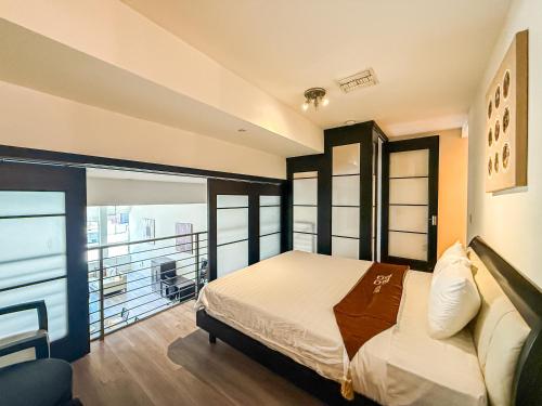 a bedroom with a bed and a balcony at Stylish 2BR Loft with Top-Tier Amenities - 104 - GL in Glendale