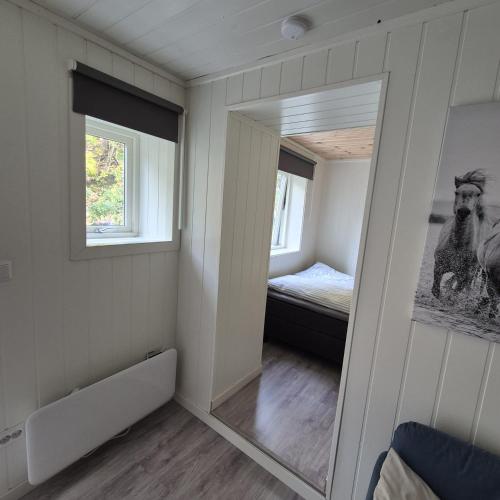 a mirror in a room with a bed and a bedroom at Just Sleep Arendal in Arendal