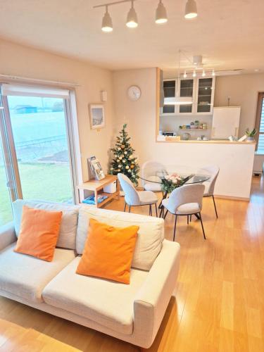 a living room with a white couch and a christmas tree at Peaceful Garden Home in Ota, Entire 3BR Parking in Ota