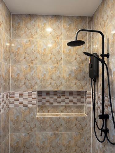 a shower in a bathroom with a stone wall at Palm Garden Villa Aonang in Ao Nam Mao