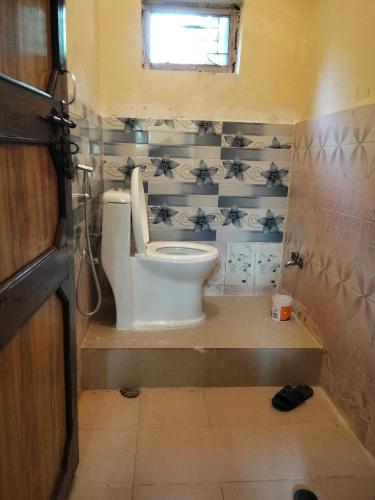 a small bathroom with a toilet and a window at Home stay number 11 , Ramechhap, Manthali in Rāmechhāp