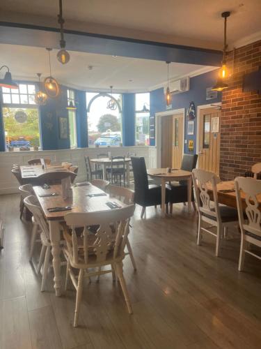 a restaurant with wooden tables and chairs in a room at Queen Phillippa in Queenborough